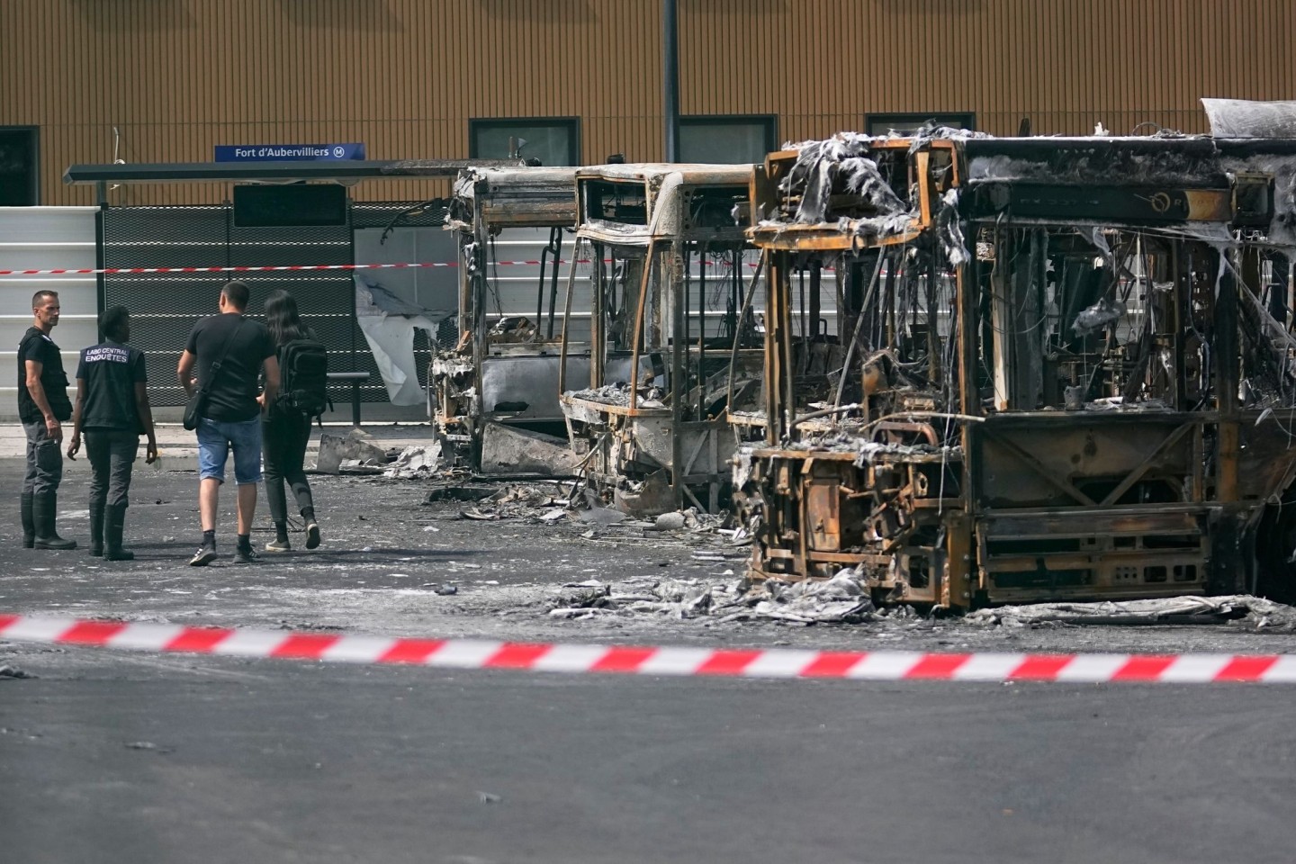 Polizeiermittler vor ausgebrannten Bussen in Aubervilliers.