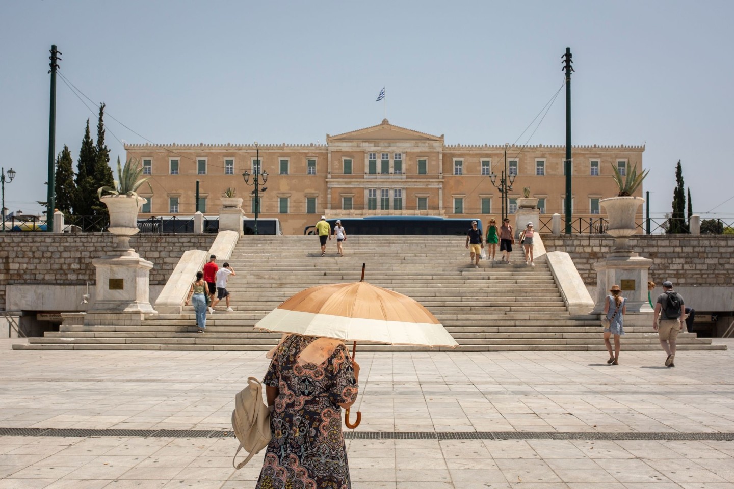 Eine Frau schützt sich mit einem Sonnenschirm auf dem Syntagma-Platz in Athen vor der Sonne: Warme Luftmassen sorgen für Temperaturen von örtlich bis zu 45 Grad.