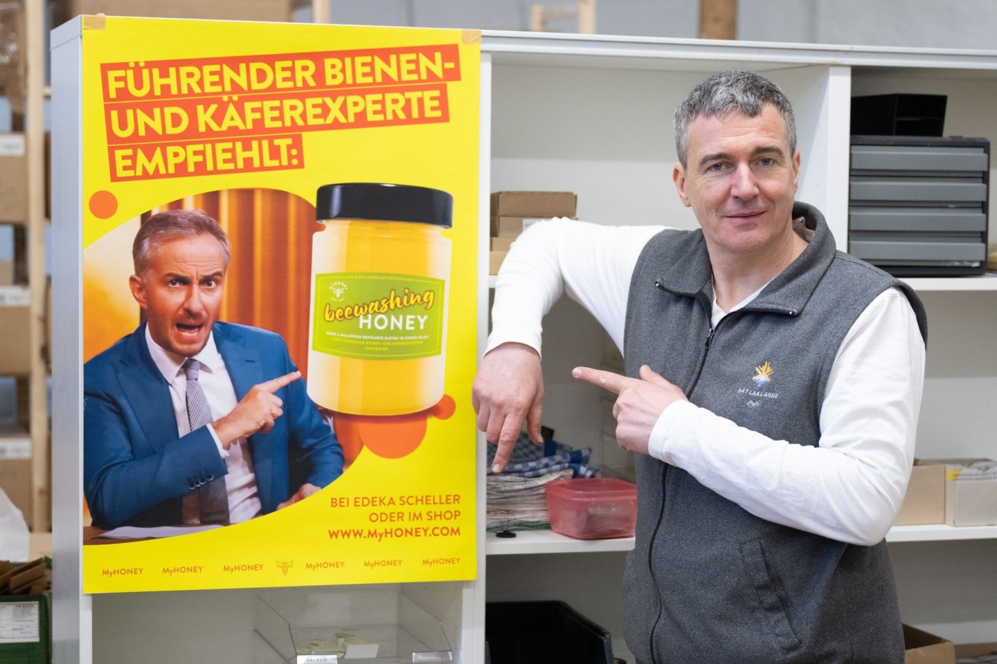 Imker Rico Heinzig neben einem Plakat mit dem Foto des Moderators Jan Böhmermann.