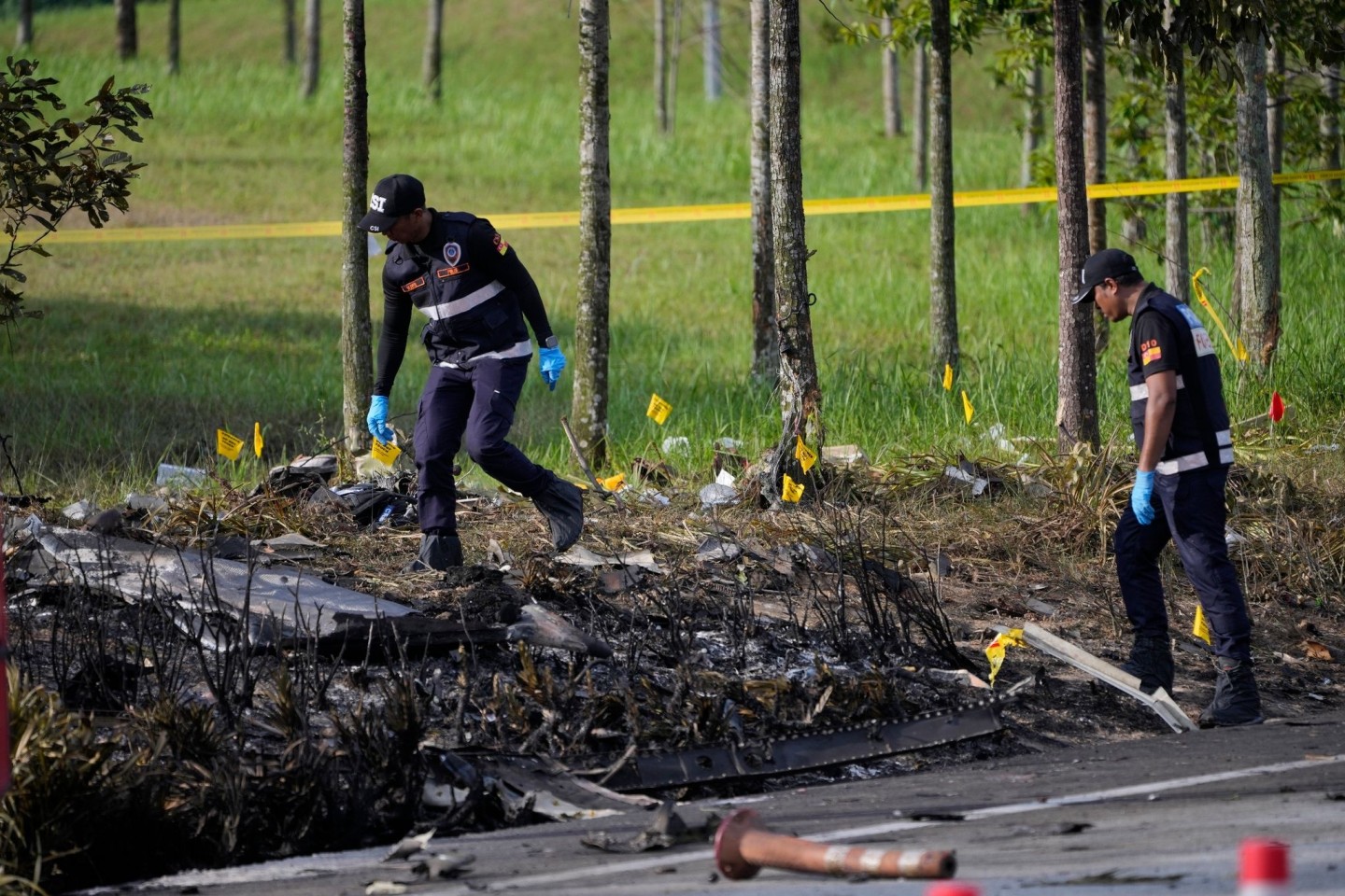 Polizisten ermittelt an der Absturzstelle des Kleinflugzeugs in Malaysia.