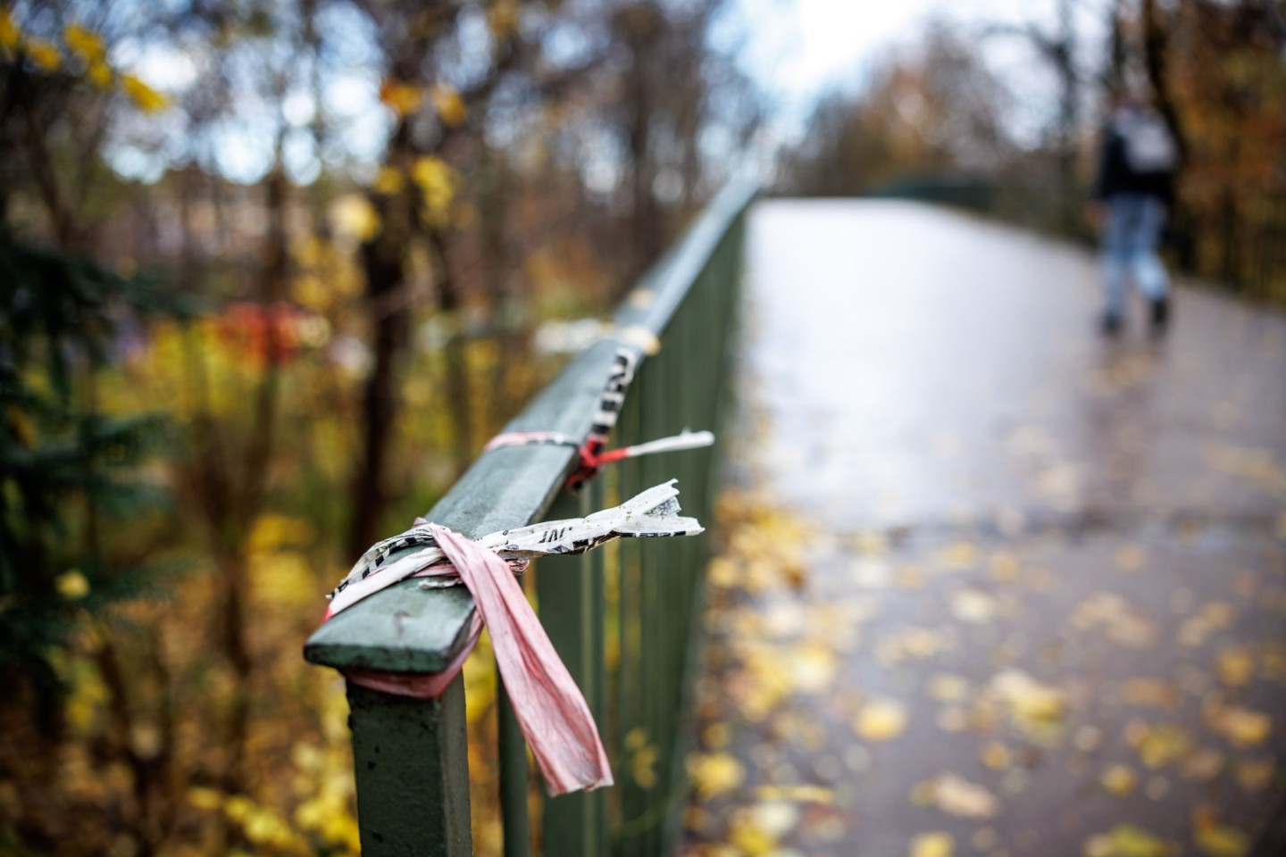 Der Rest eines Absperrbands der Polizei am Geländer einer Fußgängerbrücke im Englischen Garten in München. Dort kam das Opfer zu Tode.