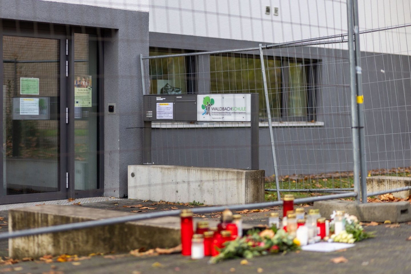 Blumen und Kerzen liegen vor der Waldbachschule in Offenburg.