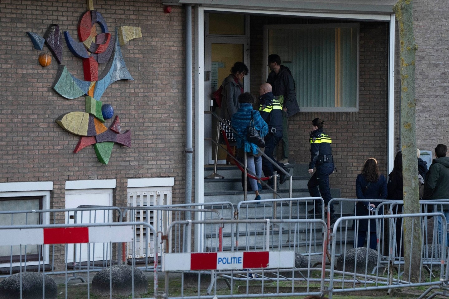 Zwei niederländische Polizeibeamte betreten das Hochsicherheitsgebäude des Gerichts.