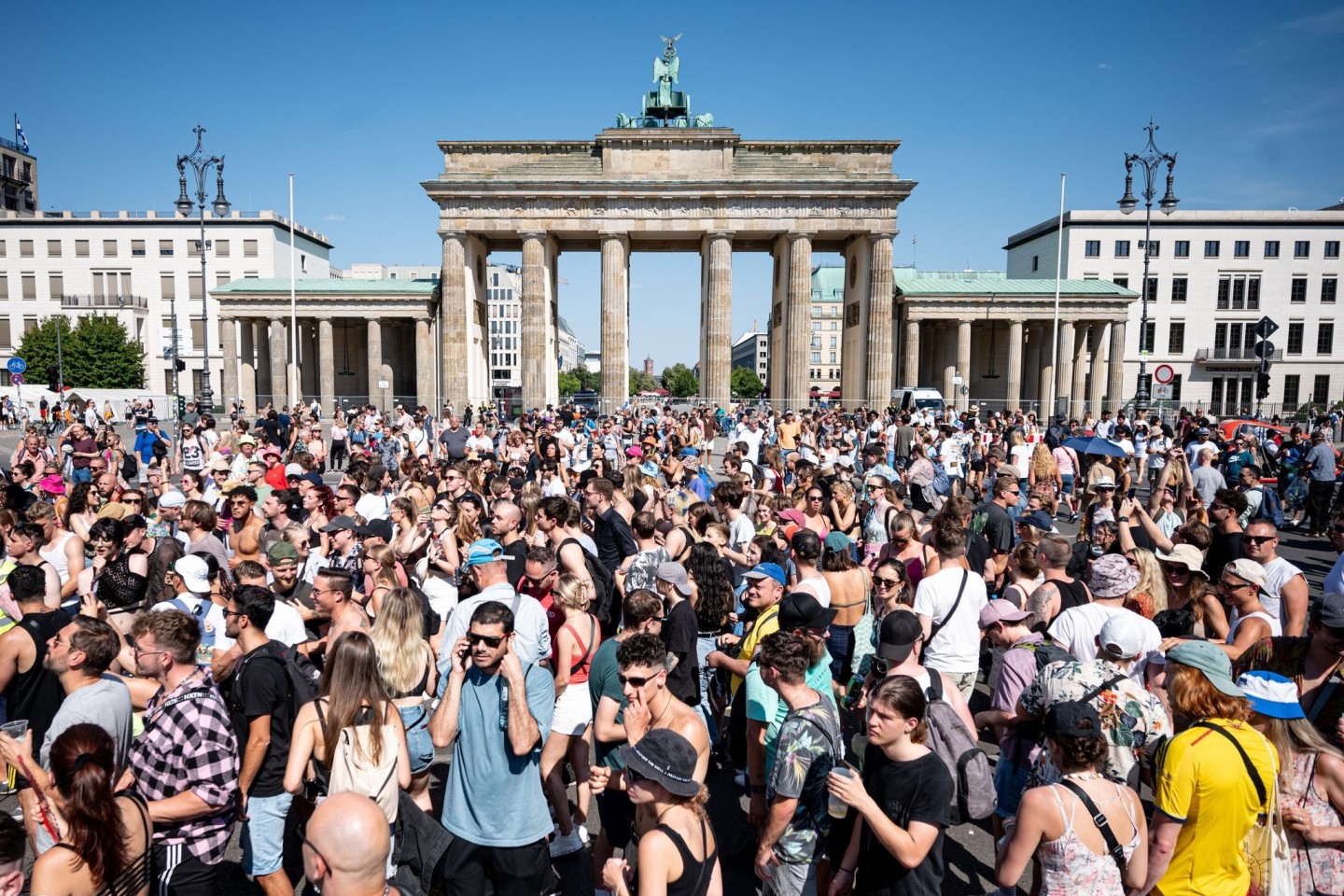 Menschen feiern vor dem Brandenburger Tor in Berlin zu Techno-Musik.