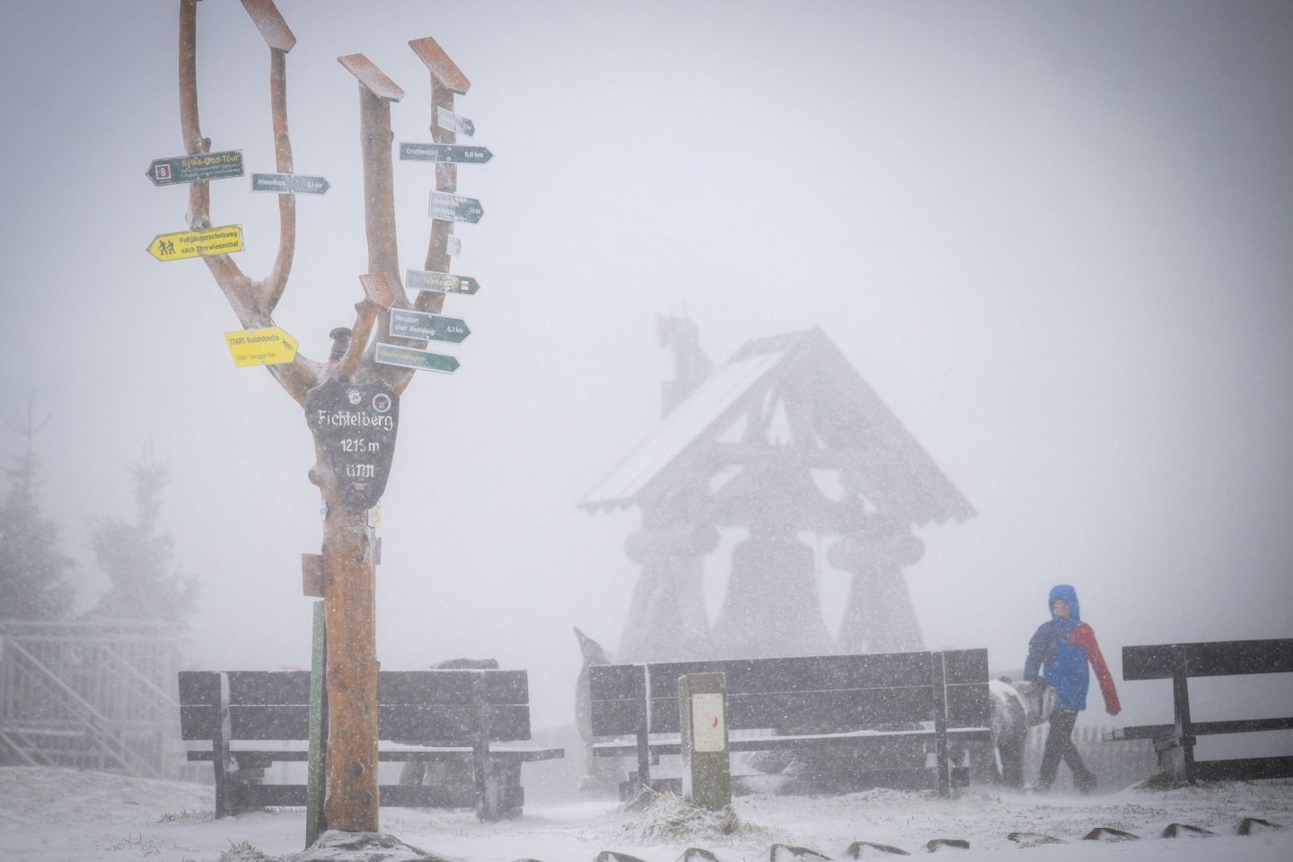 Der mit einer leichten Schneeschicht bedeckte 1215 Meter hohe Fichtelberg liegt im Nebel.