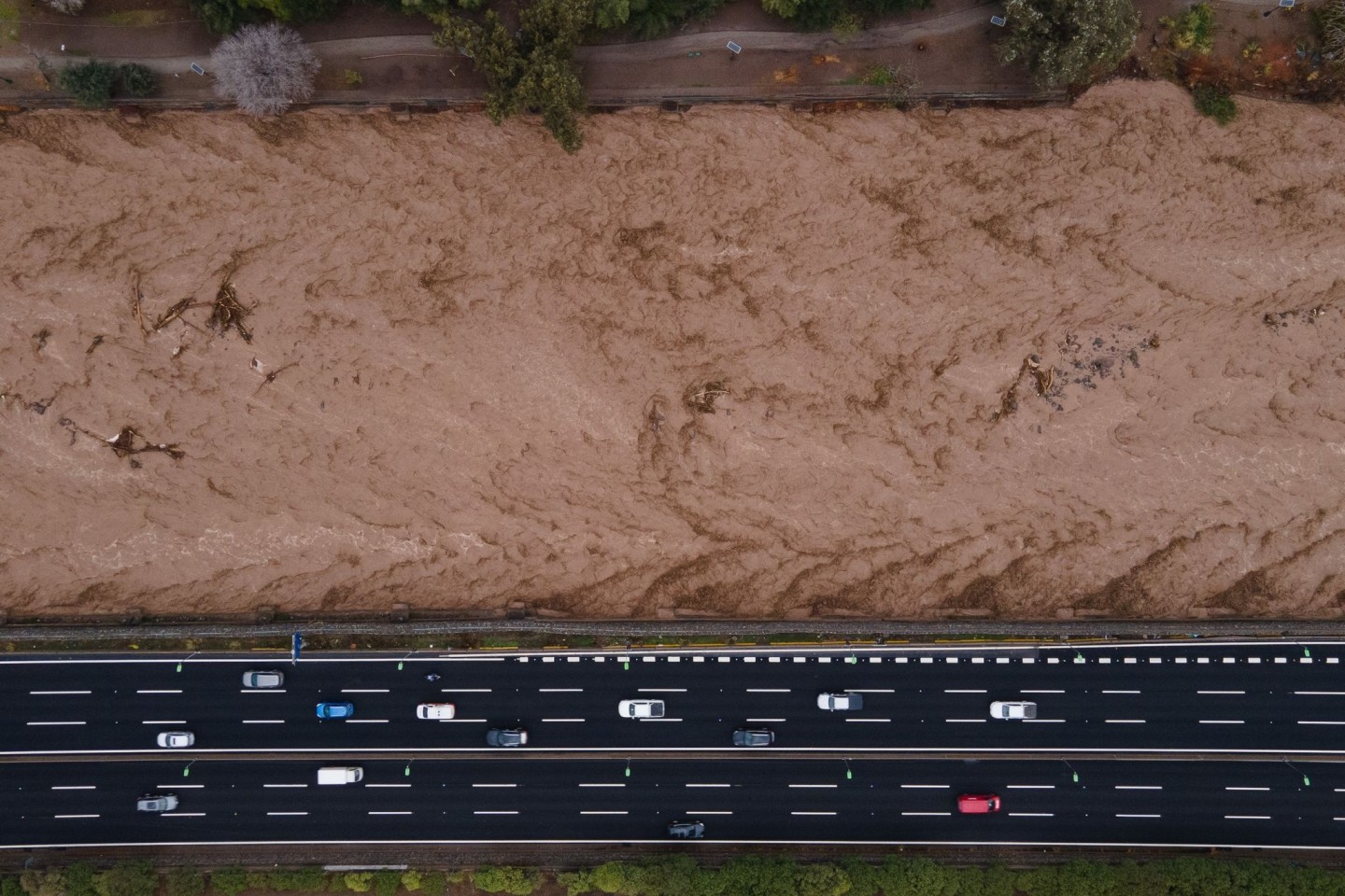 Luftaufnahme des Mapocho-Flusses in Chile voller Wasser und mit starker Strömung, inmitten eines intensiven Regens.